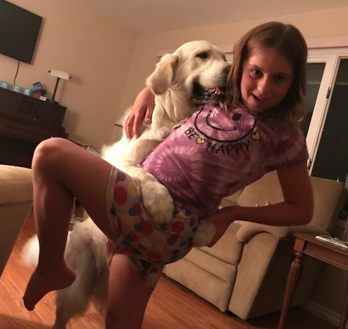 Olivia strikes a pose while dancing with cream retriever Chase in the living room.