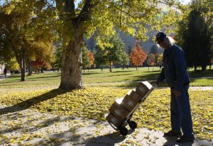 MonTECH's Resource Coordinator, Dave Gentry, pushes a hand cart loaded with boxes of AT to ship out to Montanans on a sunny, fall day.