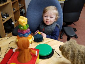 16-month-old boy presses green button to activate Curious George Jack-in-the-box.