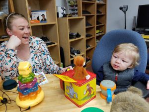 16-month-old plays with switch-adapted toys while mom cheers him on.