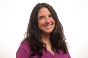 Headshot of Michelle Allen. She has long, wavy black hair and a vibrant smile.