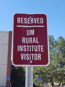 Sign designating MonTECH's parking spot, says "Reserved UM Rural Institute Visitor"